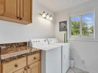 a white laundry room with a washer and dryer at 3 min. walk to Wilton Drive, pool and huge yard in Fort Lauderdale