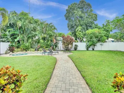 a garden with two benches and a path at 3 min. walk to Wilton Drive, pool and huge yard in Fort Lauderdale
