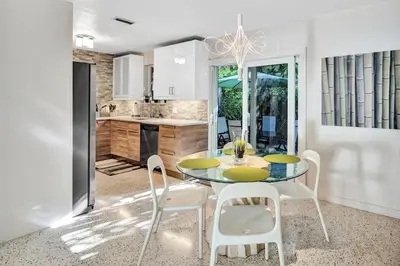 a kitchen and dining room with a table and chairs at 3bed 2bath with pool, 5 min. walk to food and fun in Fort Lauderdale