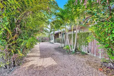 a driveway to a house with trees and a fence at 3bed 2bath with pool, 5 min. walk to food and fun in Fort Lauderdale