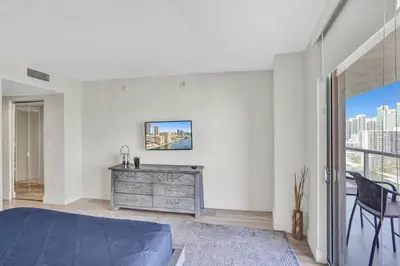a bedroom with a bed and a dresser and a window at Spacious Luxury Ocean View 4 Bdrs 3Baths 17 FL in Hallandale Beach