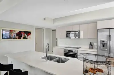 a white kitchen with a sink and a counter at Spacious Luxury Ocean View 4 Bdrs 3Baths 17 FL in Hallandale Beach
