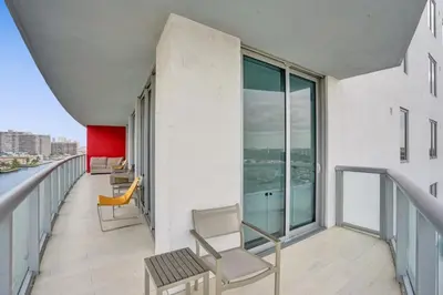 a balcony with chairs and windows on a building at Awesome Ocean View Modern Condo Pool Shuttle in Hallandale Beach