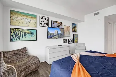 a bedroom with a bed and a chair and pictures on the wall at Luxury 2BR 2BA Water Front in Hyde Beach Resort in Hollywood