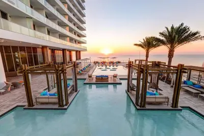 a resort pool with chairs and the ocean in the background at Luxury 2BR 2BA Water Front in Hyde Beach Resort in Hollywood