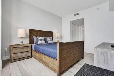 a bedroom with a large bed and two lamps at Lower Penthouse 3BD 3BA Beach Gym and Pool in Hallandale Beach
