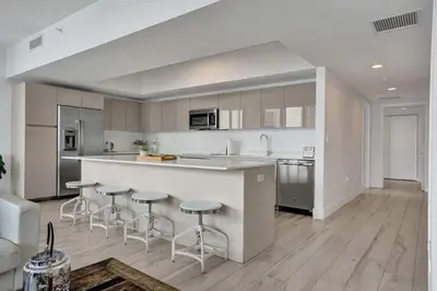 a kitchen with a counter and bar stools in it at Lower Penthouse 3BD 3BA Beach Gym and Pool in Hallandale Beach