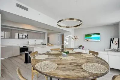 a kitchen and dining room with a table and chairs at Lower Penthouse 3BD 3BA Beach Gym and Pool in Hallandale Beach