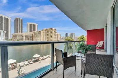a balcony with chairs and a view of the ocean at Upscale Resort 4 Bedrooms 3 bath in Hallandale Beach