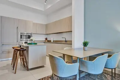 a kitchen with a wooden table and blue chairs at Oceanfront Condo Direct Ocean View Beach Access in Hollywood