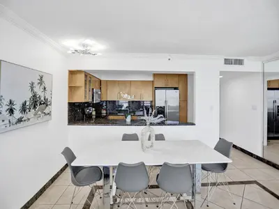 a kitchen and dining room with a white table and chairs at Beautiful condo in resort beach service 1004 in Miami Beach