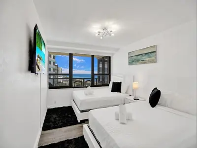 a white room with two beds and a window at Beautiful condo in resort beach service 1004 in Miami Beach