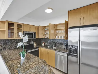 a kitchen with wooden cabinets and stainless steel appliances at Beautiful condo in resort beach service 1004 in Miami Beach