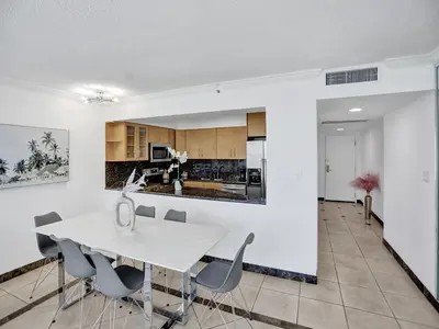 a kitchen and dining room with a white table and chairs at Beautiful condo in resort beach service 1004 in Miami Beach