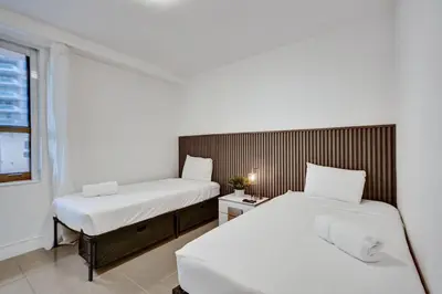 two beds in a small room with a window at Oceanfront condo beach service 411 in Miami Beach