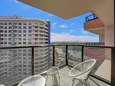a balcony with chairs and a view of a city at Cute Ocean View Condo Beach Service 1217 in Miami Beach
