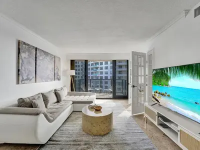 a living room with a couch and a tv at Cute Ocean View Condo Beach Service 1217 in Miami Beach