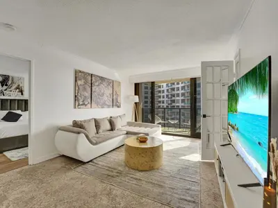 a living room with a couch and a tv at Cute Ocean View Condo Beach Service 1217 in Miami Beach