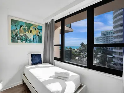 a bedroom with a bed and a large window at Adorable 2 Bedroom Condo Beach Service 605 in Miami Beach