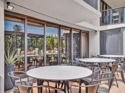 an outdoor patio with tables and chairs and windows at Amazing Ocean View Condo Beach Service 607 in Miami Beach