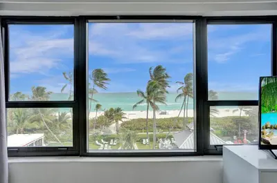 a room with three windows looking out at the beach at Spacious Ocean View Resort Beach Condo 601 in Miami Beach