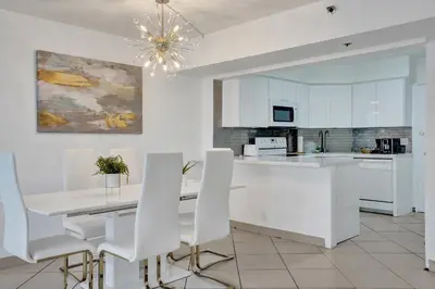 a kitchen with white cabinets and a table and chairs at Spacious Ocean View Resort Beach Condo 601 in Miami Beach