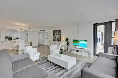 a living room with white furniture and a tv at Spacious Ocean View Resort Beach Condo 601 in Miami Beach