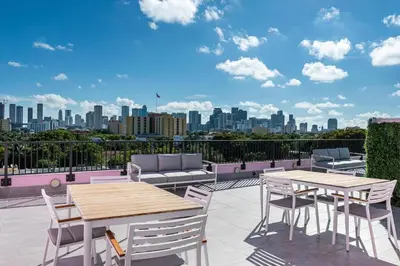 a patio with tables and chairs and a city skyline at Pastel Apartments in Miami