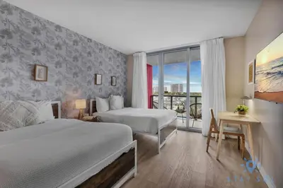 a hotel room with two beds and a window at Spectacular Apartment with Balcony Near Beach in Hallandale Beach