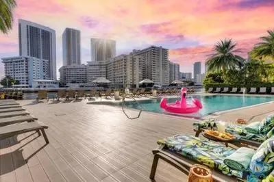 a large swimming pool with a city in the background at Spectacular Apartment with Balcony Near Beach in Hallandale Beach