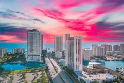 a city with tall buildings and a red cloudy sky at Spectacular Apartment with Balcony Near Beach in Hallandale Beach