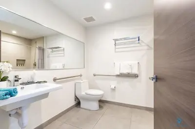 a bathroom with a toilet and a sink and a mirror at Front Bay View, Enjoy Sunsets, Amazing Pool in Hollywood