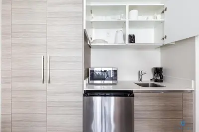 a kitchen with a stainless steel refrigerator and cabinets at The Most Liked Homes Hot tub & Unique Rooftop in Hollywood
