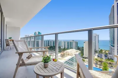 a balcony with chairs and a table and a view of the ocean at Awesome Ocean View and Amenities, Pools - 2 BR in Hollywood