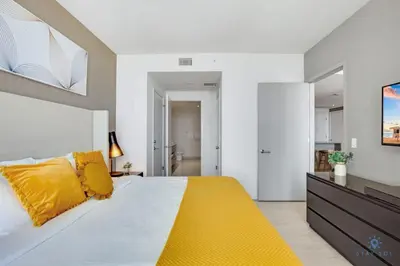 a bedroom with a large bed with yellow pillows at Awesome Ocean View and Amenities, Pools - 2 BR in Hollywood