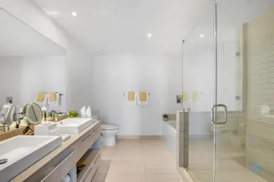 a white bathroom with two sinks and a shower at Awesome Ocean View and Amenities, Pools - 2 BR in Hollywood