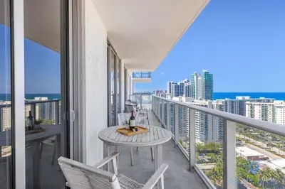 a balcony with a table and chairs and a view of the city at Breathtaking Front Ocean View: Amazing Pools in Hollywood