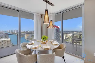 a dining room with a table and chairs and large windows at Luxury 3 BR Stunning View & High Floor Hot Tub in Hollywood