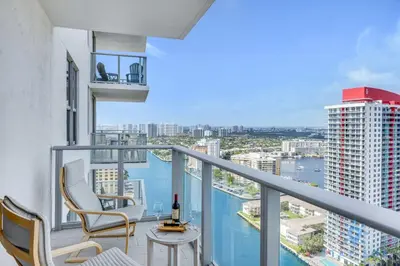 a balcony with chairs and a table and a view of the water at Luxury 3 BR Stunning View & High Floor Hot Tub in Hollywood
