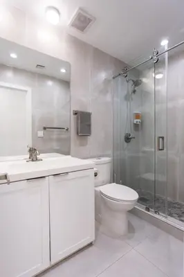 a white bathroom with a shower and a toilet at WALK to Hollywood Beach Spectacular 5BR and 5BA Villa in Hollywood