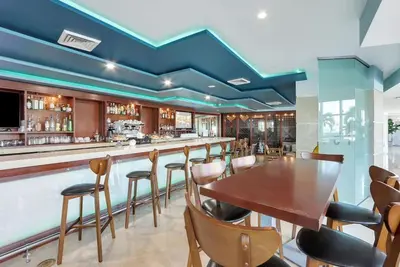 a bar with a wooden table and chairs at Beachfront with direct beach access and amazing views in Aventura