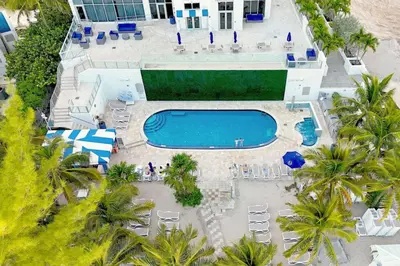 an aerial view of a resort with a pool and palm trees at Beachfront with direct beach access and amazing views in Aventura