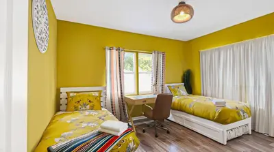 a yellow room with two beds and a desk at NEW! Havana Nights Villa ! Walk to Calle Ocho! in Miami