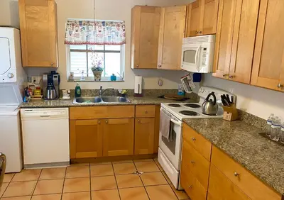 a kitchen with wooden cabinets and a white stove top oven at Judit’s in Dania in Dania Beach