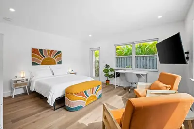 a bedroom with a bed and a desk and chairs at Morning Sunshine @Sailboat Bend in Fort Lauderdale