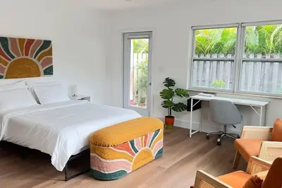 a bedroom with a bed and a desk and windows at Morning Sunshine @Sailboat Bend in Fort Lauderdale