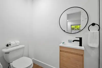 a white bathroom with a toilet and a mirror at Spacious 2 BR @Sailboat Bend in Fort Lauderdale