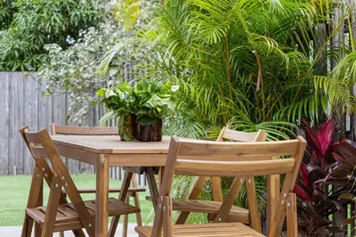a wooden table with two chairs and a vase of plants at Awesome 1BR Apartment @Sailboat in Fort Lauderdale