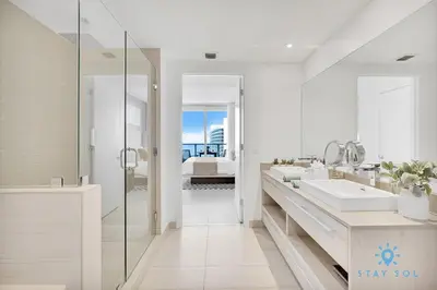 a white bathroom with two sinks and a shower at Beach House Design in Hollywood
