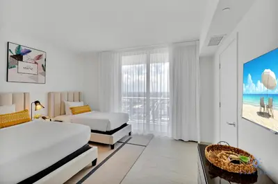 a white hotel room with two beds and a window at Beach House Design in Hollywood